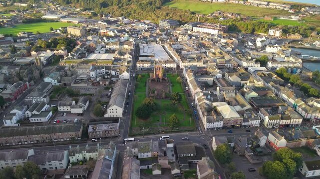 Aerial panoramic views of Whitehaven coastal town and civil parish. Town centre with architecture and main roads with moving vehicles in Sunrise, golden hour. Drone POV exploration of Devon County, UK