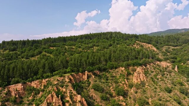 Stob pyramids green pine forest hill aerial view sandstone rock formations Rila mountain landscape nature ecosystem travel destination Stob Bulgaria horizontal video stock footage