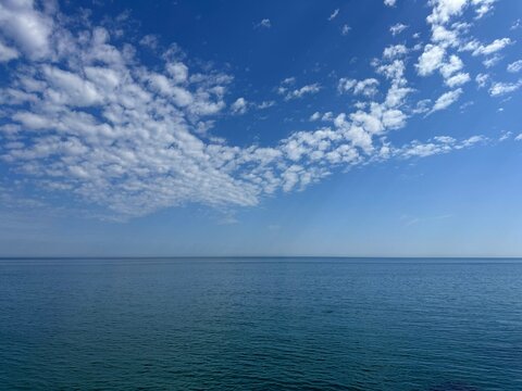 Sky with fluffy clouds over calm ocean