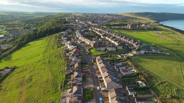 Aerial panoramic views of Whitehaven coastal town and civil parish. Town centre with architecture and main roads with moving vehicles in Sunrise, golden hour. Drone POV exploration of Devon County, UK