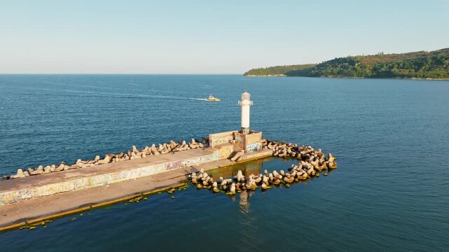 Varna port lighthouse aerial view breakwater pier Black Sea coast sunset light maritime navigation Varna Bulgaria summer travel tourism concept horizontal video stock footage
