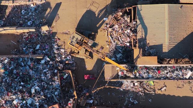 Excavator Sorting and Moving Piles of Debris at an Industrial Waste