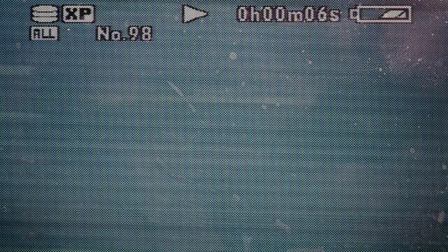 Light on old camcorder screen with pixel signal, playback overlay, fingerprints on display, video overlay via blend mode in 4k.