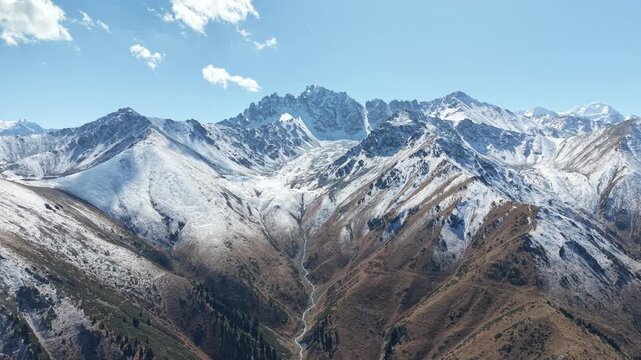 Cinematic 4K drone video ascending 500 meters high to perform full panoramic survey over melting glaciers, fresh September snow, and peaks of Issyk Bash near Akbulak in Tian Shan mountains, Kazakhstan