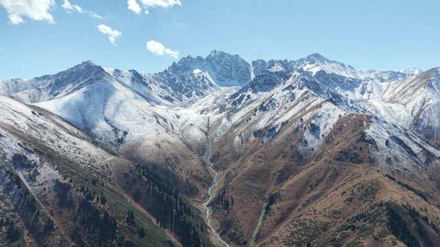 Cinematic 4K drone video ascending 500 meters high to perform full panoramic survey over melting glaciers, fresh September snow, and peaks of Issyk Bash near Akbulak in Tian Shan mountains, Kazakhstan