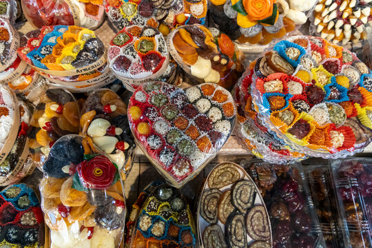 Colorful assortment of traditional Armenian sweets made from dried fruit and nuts displayed in a heart shaped box with sesame seeds at a market stall, Yerevan, Armenia