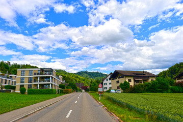 Fahrt am Ortseingang von Landikon mit Blick auf moderne Wohnhäuser und den Uetliberg, Kanton Zürich, Schweiz © Ilhan Balta