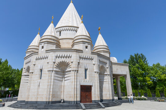 View from below of the tall white stone conical towers and carved windows of the Quba Mere Diwane Yezidi temple rising against a clear blue summer sky, Aknalich, Armenia