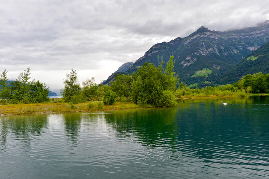 Blick &uuml;ber den malerischen Lorelei-Badesee im Reussdelta vor den m&auml;chtigen Berggipfeln bei Fl&uuml;elen, Kanton Uri, Schweiz