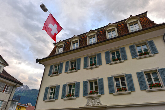 Altdorf, Gemeindehaus im Abendlicht mit Schweizer Flagge im Kanton Uri, Schweiz