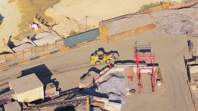Yellow Front Loader Moving Heavy Scrap Metal in an Industrial