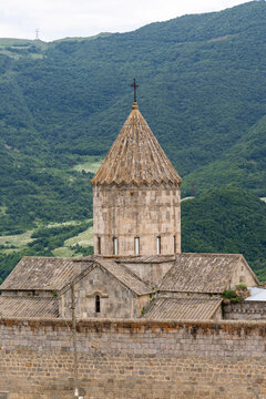 Close up of the conical stone roof and cross atop the Tatev Monastery bell tower showing intricate carved ornament and weathered ancient stonework texture, Tatev, Armenia