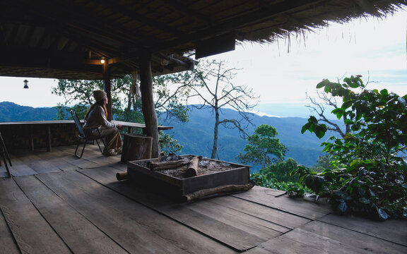 A woman sitting on wooden terrace and looking at nature views