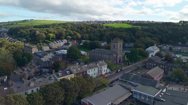 Aerial panoramic views of Whitehaven coastal town and civil parish. Demonstration of St James Church and Town centre with architecture and main roads. Drone POV exploration of Devon, England, UK