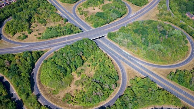 Aerial View of a Highway Cloverleaf Amidst Green Trees