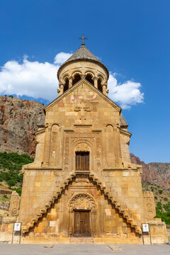 The front facade and stone staircase of Surb Astvatsatsin church display carved reliefs a wooden door and a bell tower rotunda at the Noravank monastery, Noravank, Armenia