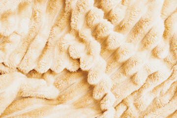 Fluffy beige plush fleece blanket fabric texture with striped ribbed pattern and soft wavy folds for cozy home interior decor manufacturing background © moryachka