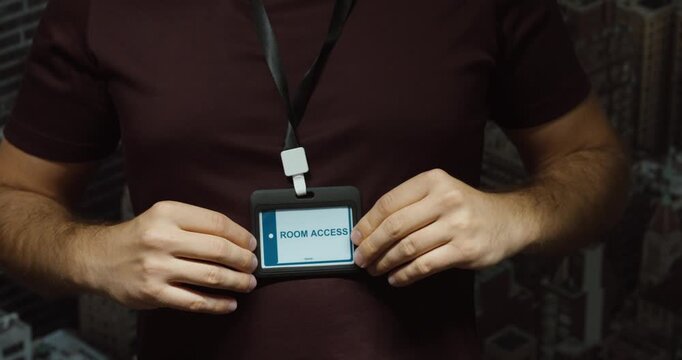 Close-up of a person putting on and adjusting a room access badge with lanyard. Concept for hotel entry, guest authorization, security and accommodation.