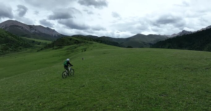 Aerial footage of woman riding mountain bike on beautiful forest mountain trail