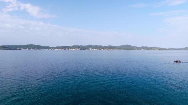 Fly up over the sea at the coast of Zadar, view of Preko and some boats, Croatia