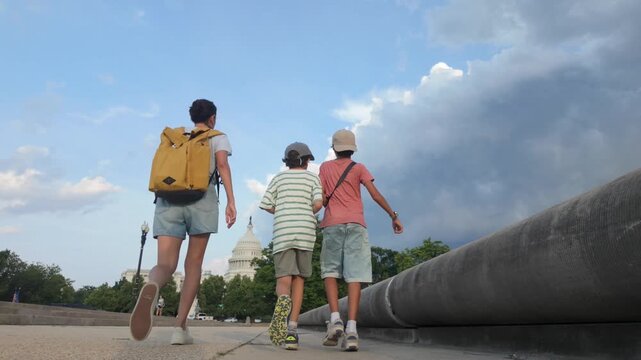 Mother with sons visiting the united states capitol building in washington dc, exploring the city and enjoying a family vacation while walking together on a sunny day