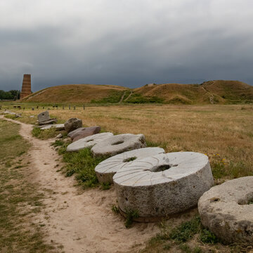 Ancient old millstones line a small foot path up to the Burana tower central Asia Kyrgyzstan as dark storm clouds overhead 