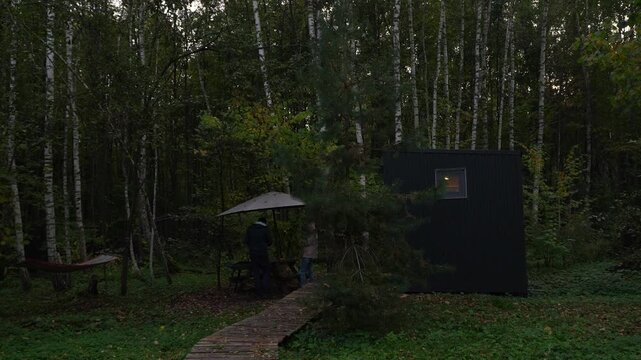 Glamping Couple Grilling Shashlik in Birch Forest from Evening to Night	Accelerated 4K footage of a young couple grilling shashlik outside a cozy glamping cabin near Tula, Russia. Surrounded by birch 