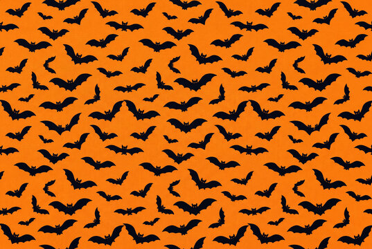 Halloween seamless pattern with black bats on an orange background. Spooky holiday background for wrapping paper and festive design.