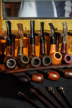 Handcrafted wooden tobacco pipes lined up on a display stand