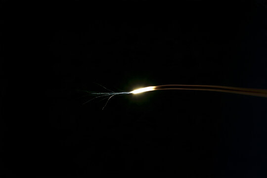 Faint pulse of light travelling along a slender axon in darkness, nerve impulse