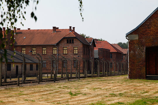 Brick barracks and electric fence at Auschwitz concentration camp