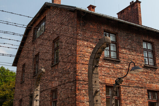 Brick barrack behind barbed wire fence at Auschwitz concentration camp