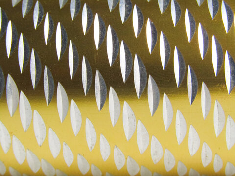 Shiny gold metal with symmetrical oval pattern &mdash; luminous texture background