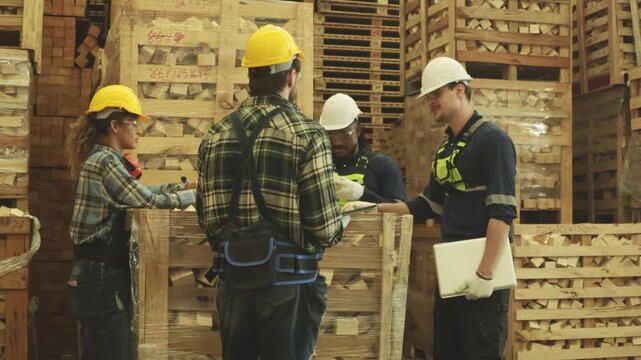 Team male and female carpenters is inspecting selecting rectangular hardwood pieces stored in wooden crates intended production heavy duty pallets such construction cargo handling industries.