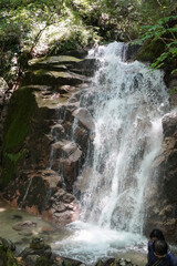 Forest waterfall cascading over rocks along the Nakasendo hiking route in Japan © poly_lou