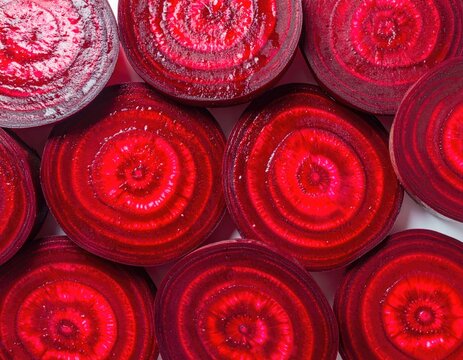 Sliced red beets reveal concentric rings and vibrant jewel tones