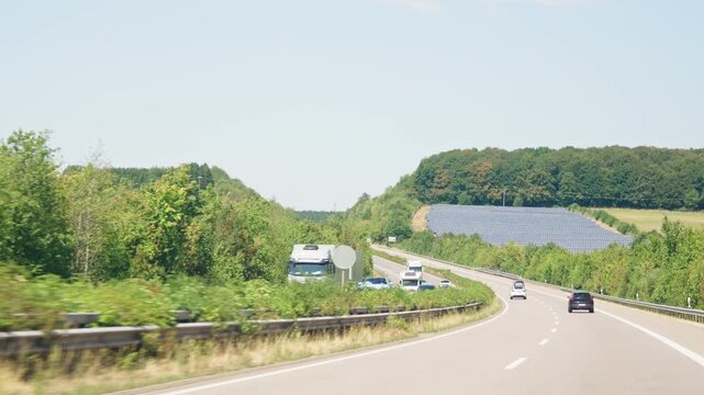 Highway curve with cars and solar farm slow motion road trip