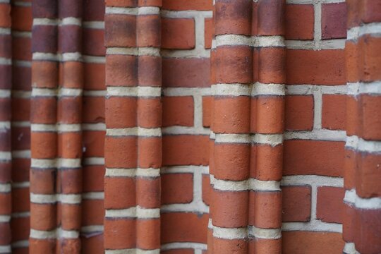 Detailaufnahme einer roten Backsteinwand mit strukturierten S&auml;ulen und hellem Fugenm&ouml;rtel der Dorfkirche Pankow in Berlin.