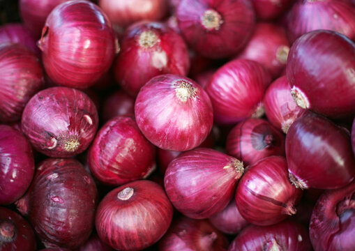 Fresh red onions piled in a market