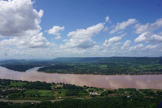 A breathtaking high-angle view overlooking the winding Mekong River from the famous viewpoint of Wat Pha Tak Suea in Sang Khom, Nong Khai, Thailand.