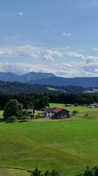 Panoramic view of a picturesque Bavarian village among green hills and dense coniferous forests. Concept of ecological tourism and outdoor recreation. Scenic rural landscape. Nature