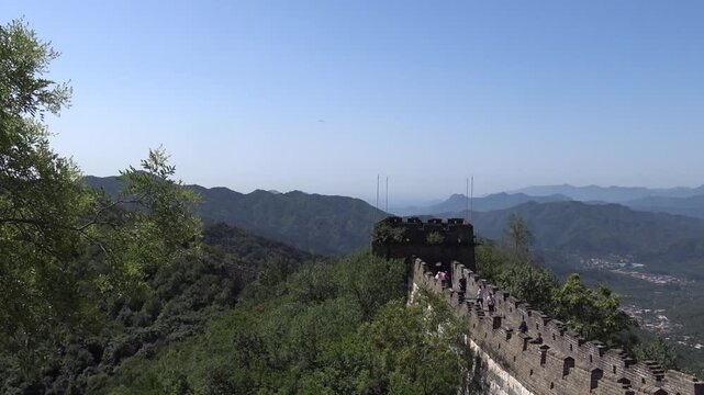 Great Wall of China watchtower and battlements over forested mountains