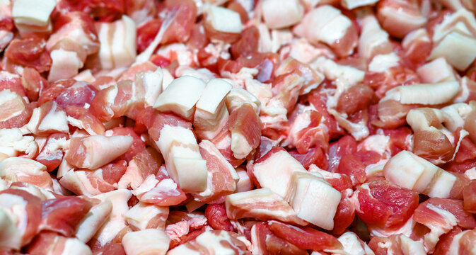 Fresh raw pork fat and fatty pork cut into small pieces, prepared for cooking and rendering lard, showing the texture of meat and fat as ingredients for food preparation and meat processing