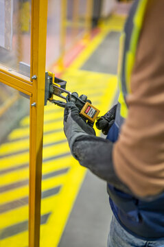 Hands locking LOTO lockout tagout lock on the door, hand closeup