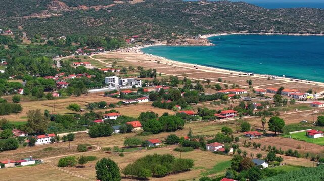 Aerial drone view of Sikia Beach (Paralia Sikias) on the Sithonia peninsula in Halkidiki, Greece, featuring a long sandy shoreline, clear blue Aegean waters and scenic coastal landscape