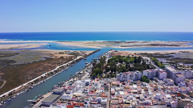Majestic aerial view of the charming fishing village of fuseta in the algarve region, portugal, showing the ria formosa natural park and the beautiful blue waters of the atlantic ocean