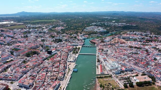 Beautiful aerial perspective of the historic city of tavira, featuring the gilao river, the ancient roman bridge, and traditional portuguese architecture under a bright sunny sky