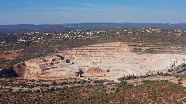 Aerial view of a vast open pit quarry showing the terraced layers from aggregate and mineral extraction, highlighting the industrial landscape and the scale of modern mining operations