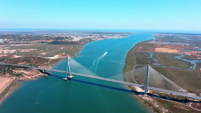 Majestic aerial view of the guadiana international bridge spanning the river between ayamonte, spain, and vila real de santo antonio in the algarve region of portugal under a clear blue sky