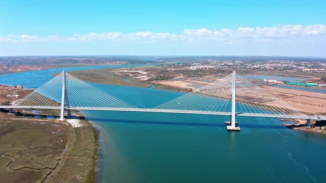 Majestic aerial view flying over the guadiana international bridge, an impressive cable stayed structure spanning the river that forms the border between ayamonte, spain, and castro marim, portugal